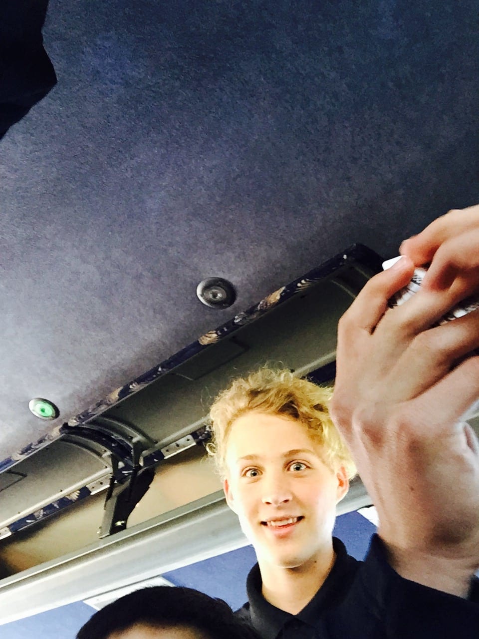 Sean watching his friends play cards on the team bus.