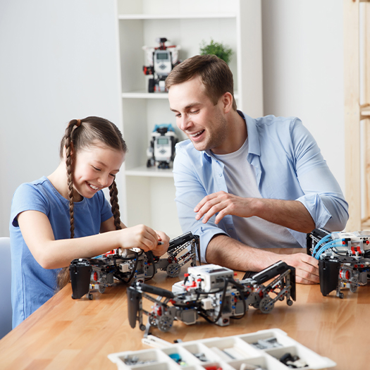 a father and daughter building robots together