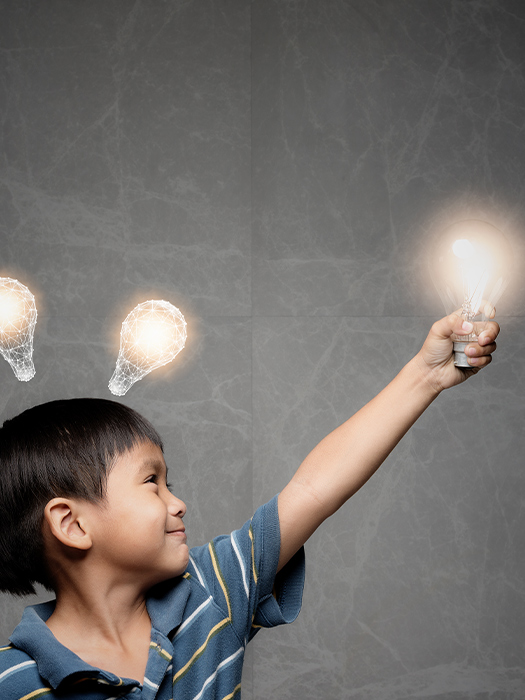 a boy holding a lightbulb