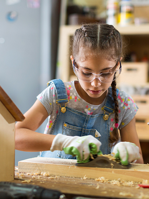a girl using a wood planer