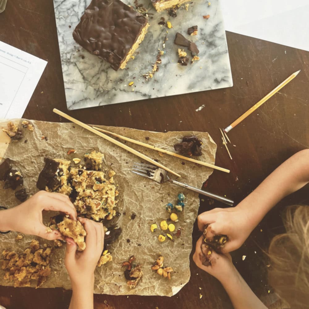 Homeschool Science Edible Fossil Dig - Two Children Digging Through Cookie to Find Fossils (Candy)