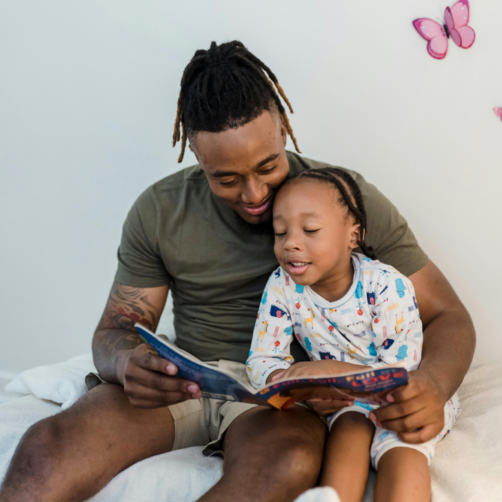 Reading for book club - Man And Child Sit Together Reading a Book