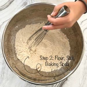 Chocolate Chip Cookie Chemistry Activity: Bowl on Table with Hand Whisking Flour, Baking Soda, and Salt Together