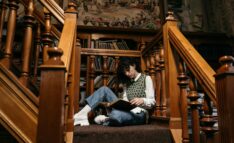 Homeschool History: Historical Reading, Writing, and Thinking - Person Sits on Landing of Beautiful Wooden Staircase Reading Books