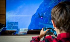 Game Based Learning: Child Sits in Front of TV Holding Game Controller and Playing Video Games