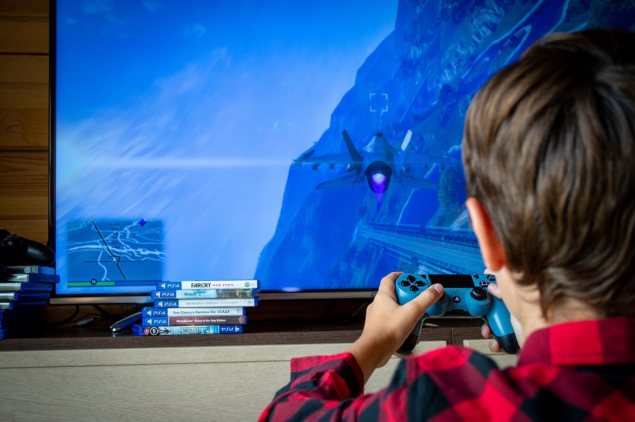 Game Based Learning: Child Sits in Front of TV Holding Game Controller and Playing Video Games