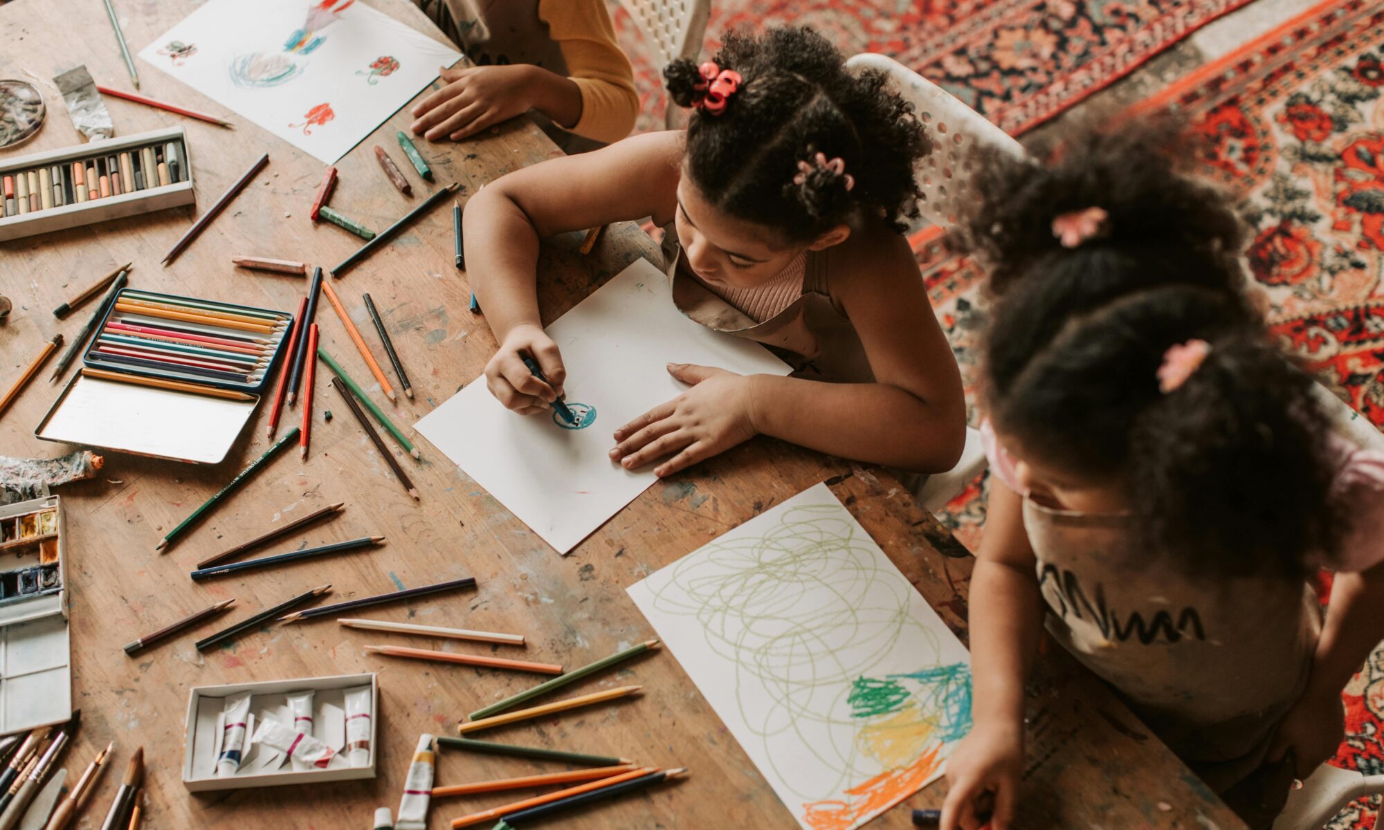 Homeschool Strewing: Children at a table with a lot of art supplies. Each child is working on their own project.