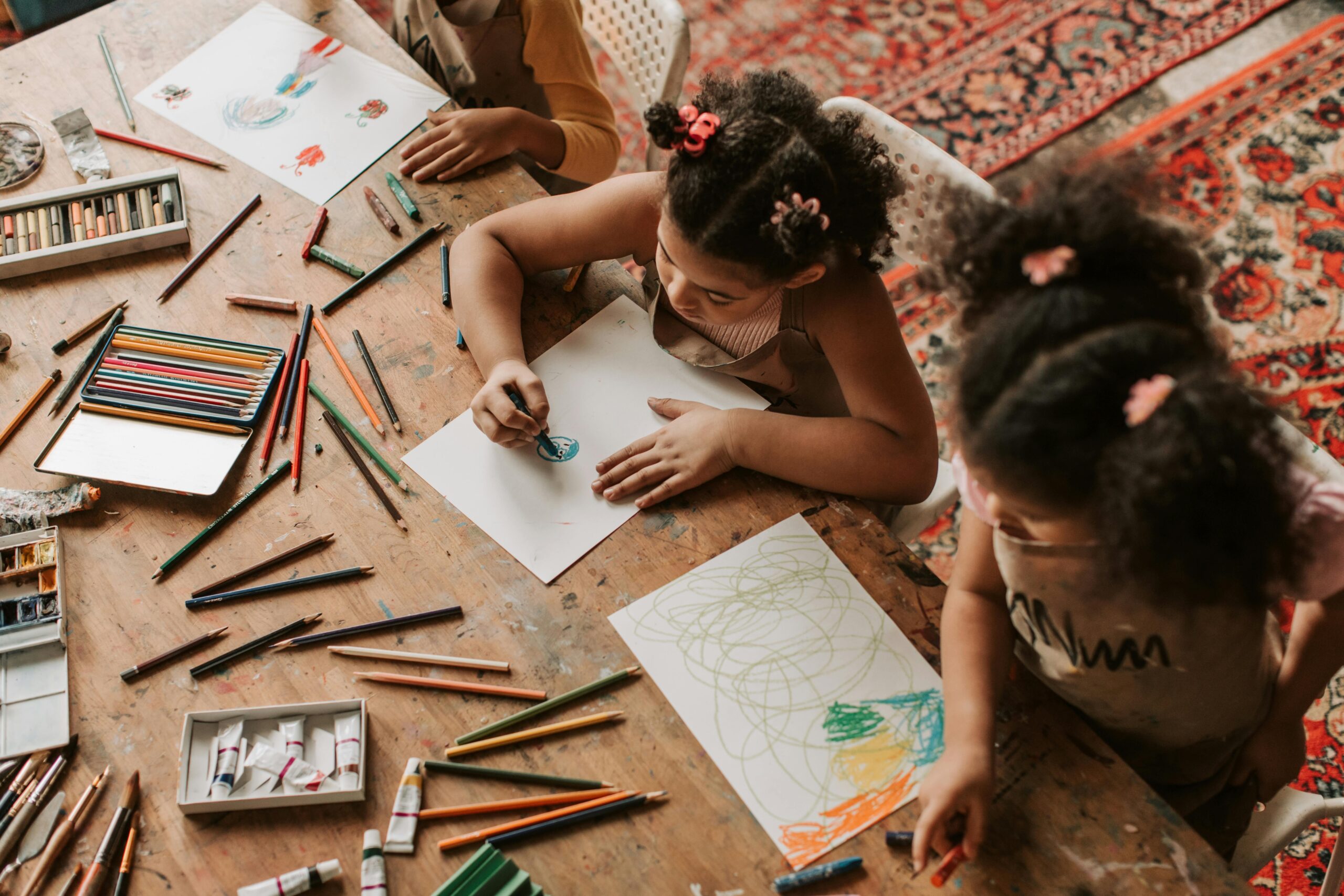 Homeschool Strewing: Children at a table with a lot of art supplies. Each child is working on their own project.