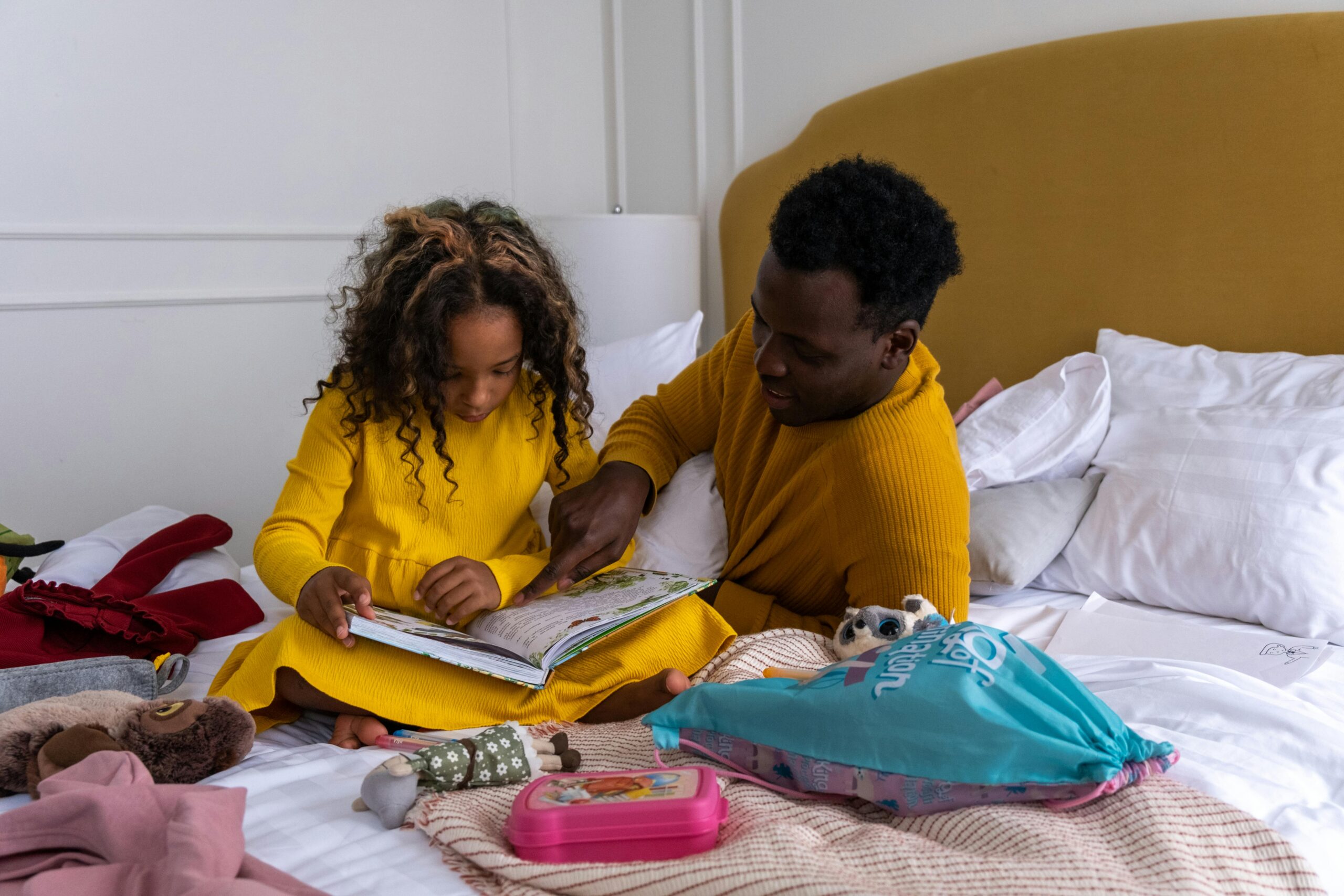 Critical Thinking: Metrics and Methods - Man sitting on bed with little girl reading a book to her